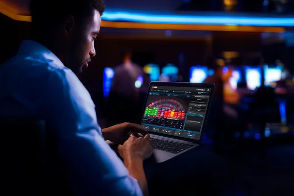 সোনালি কয়েনের ঝর্ণার মধ্যে ঘূর্ণায়মান একটি রুলেট চাকার ক্লোজ-আপ—যা KK33E–এ গভীর ক্যাসিনো অ্যাকশনকে তুলে ধরে।